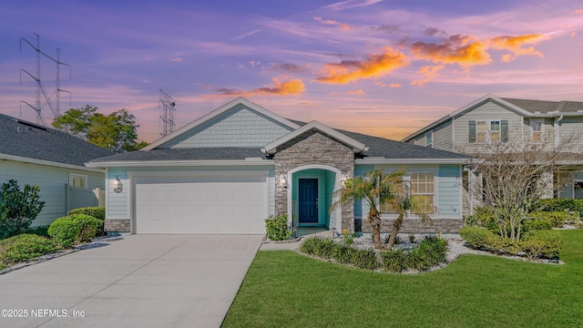 view of front of house featuring stone siding, driveway, a front lawn, and a garage