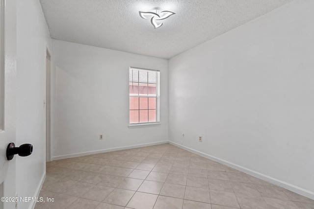 spare room featuring baseboards and a textured ceiling