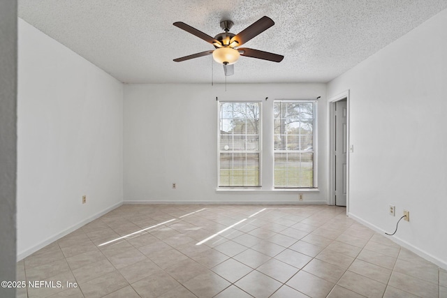 unfurnished room with a textured ceiling, light tile patterned flooring, baseboards, and ceiling fan