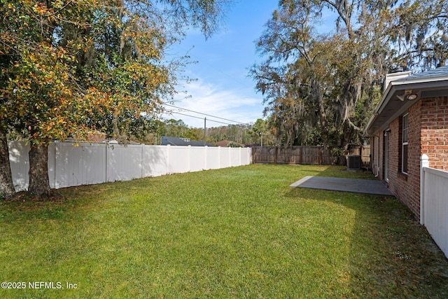 view of yard with a patio area, central AC unit, and a fenced backyard