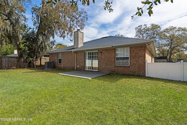 back of house featuring a lawn, a patio, central AC, and a fenced backyard