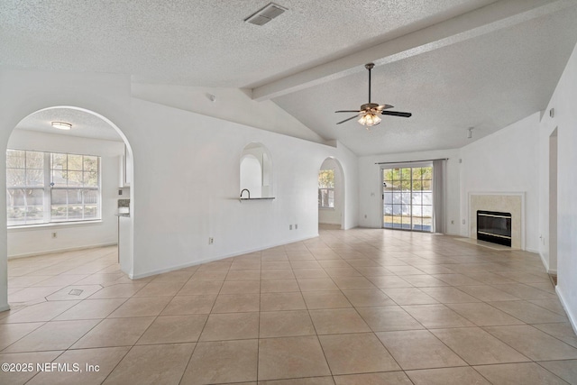 unfurnished living room featuring light tile patterned floors, visible vents, lofted ceiling with beams, arched walkways, and ceiling fan