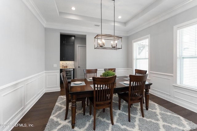 dining room featuring dark wood-style floors, wine cooler, and a raised ceiling