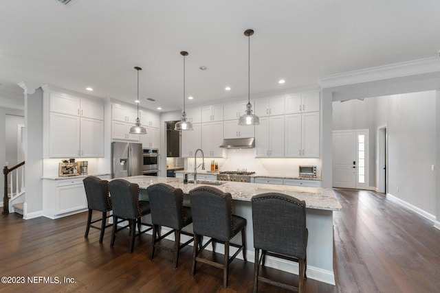 kitchen with under cabinet range hood, stainless steel appliances, white cabinetry, and a sink