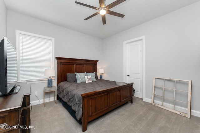 bedroom with a ceiling fan, light colored carpet, and baseboards