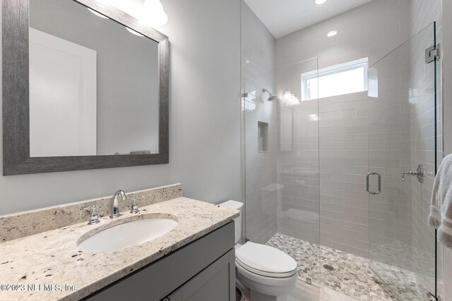 bathroom with vanity, toilet, and a stall shower