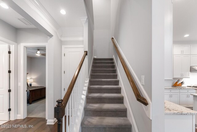 staircase with visible vents, crown molding, baseboards, recessed lighting, and wood finished floors