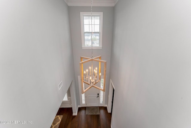 entrance foyer featuring visible vents, crown molding, baseboards, an inviting chandelier, and wood finished floors