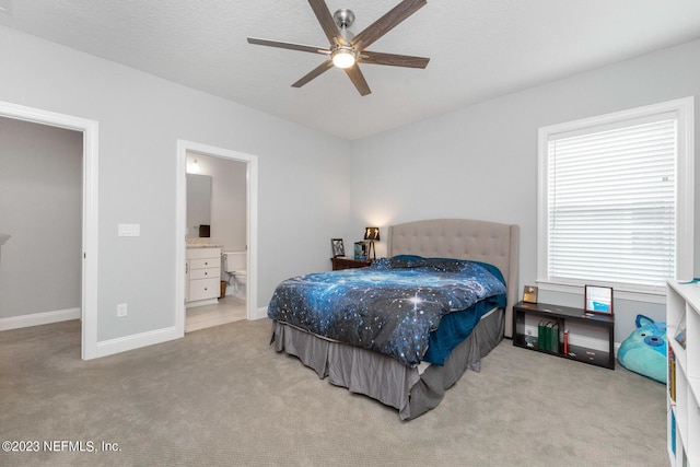 bedroom featuring baseboards, carpet floors, connected bathroom, and a ceiling fan