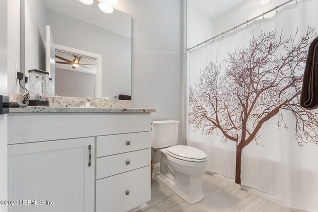 full bathroom with vanity, shower / tub combo, toilet, and ceiling fan