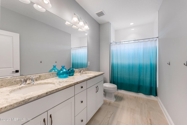 full bath featuring double vanity, visible vents, toilet, and a sink