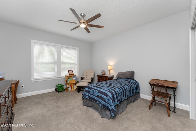 carpeted bedroom with a ceiling fan, baseboards, and a textured ceiling