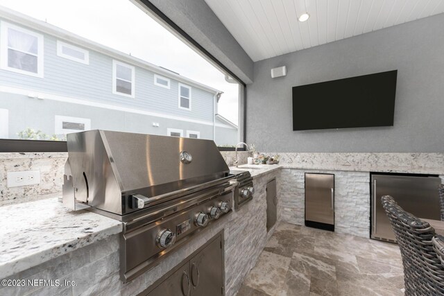 view of patio featuring grilling area, exterior kitchen, and a sink