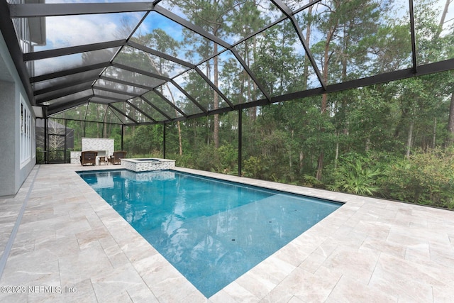 view of swimming pool featuring a patio area, a lanai, and a pool with connected hot tub