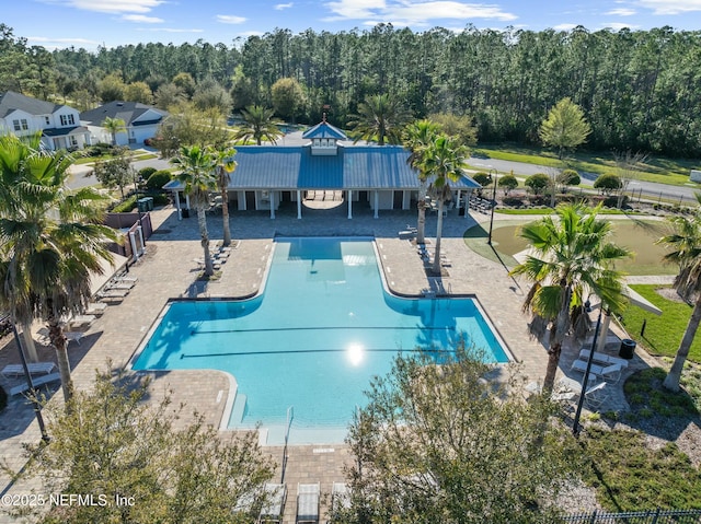 pool with a patio and fence