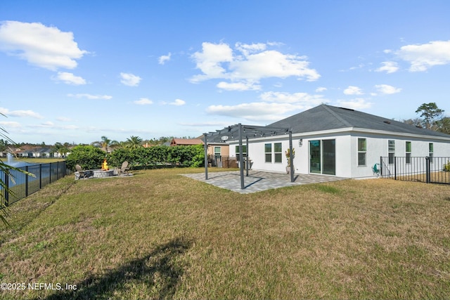 rear view of house featuring stucco siding, a lawn, a fenced backyard, and a patio area