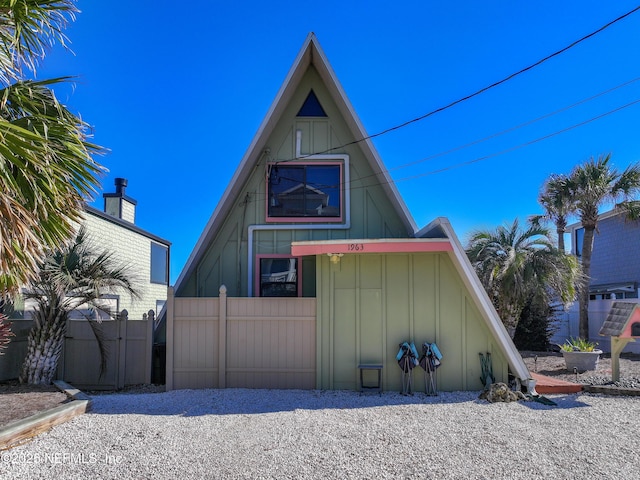 view of front facade with fence and board and batten siding