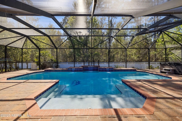 pool featuring a patio area, a lanai, and a hot tub