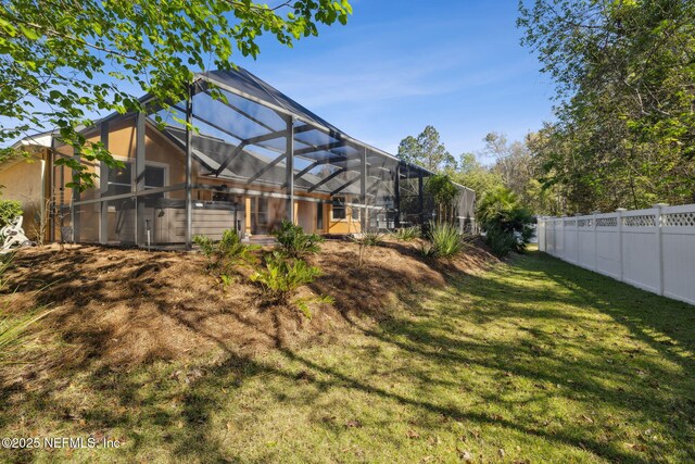 view of yard with glass enclosure and a fenced backyard