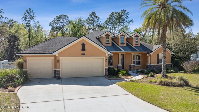 view of front of home with stucco siding, stone siding, fence, concrete driveway, and a garage