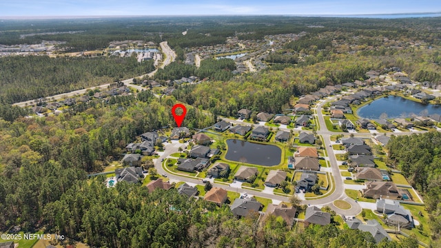 drone / aerial view featuring a forest view, a residential view, and a water view