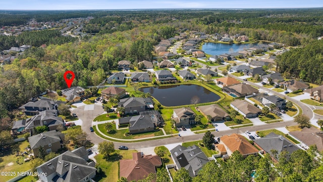 birds eye view of property with a forest view, a water view, and a residential view