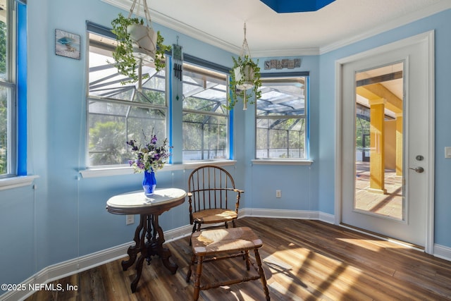 sitting room featuring baseboards, wood finished floors, and ornamental molding