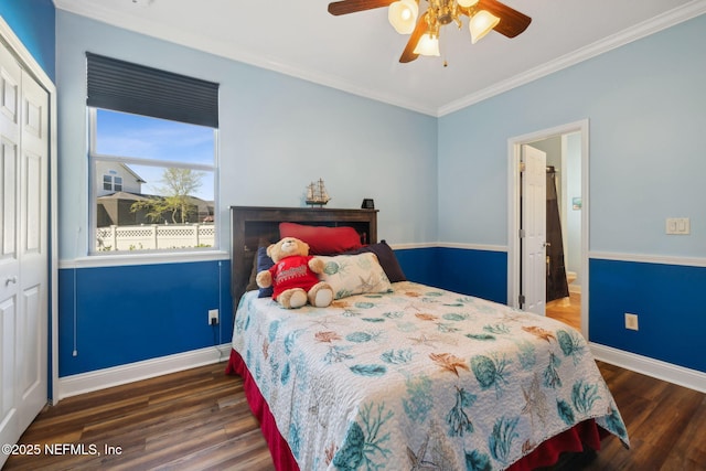 bedroom with a closet, baseboards, wood finished floors, and ornamental molding