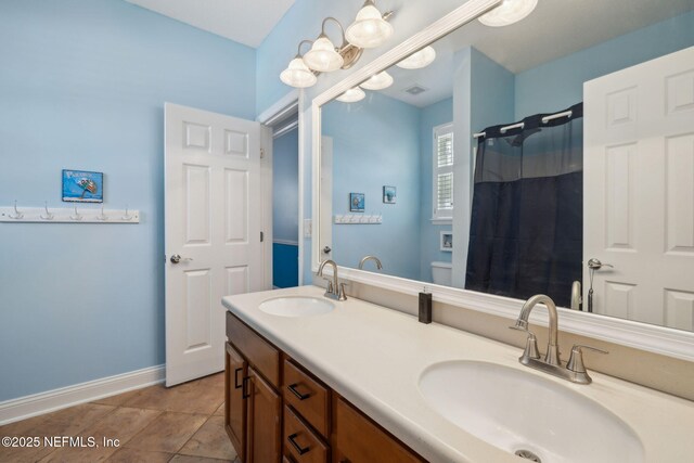 bathroom with visible vents, toilet, baseboards, and a sink