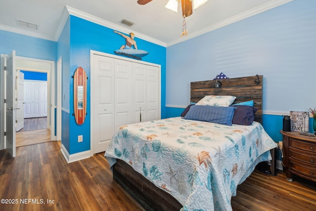 bedroom with wood finished floors, visible vents, and a closet