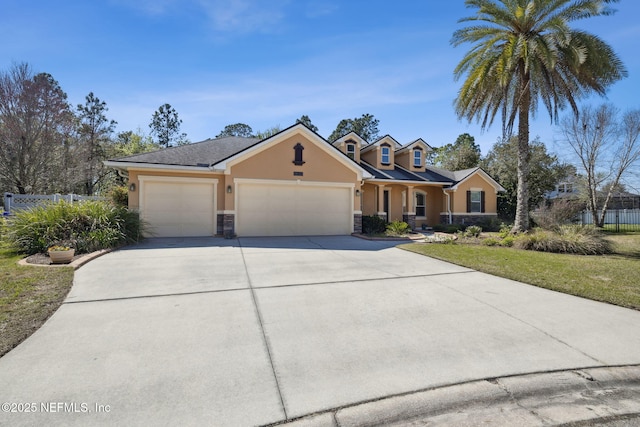 view of front facade featuring stucco siding, stone siding, fence, concrete driveway, and a garage