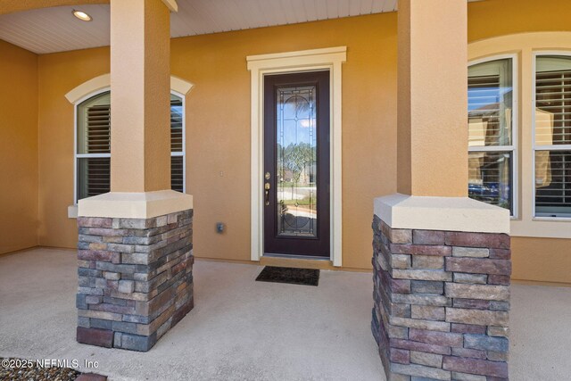 doorway to property featuring stucco siding