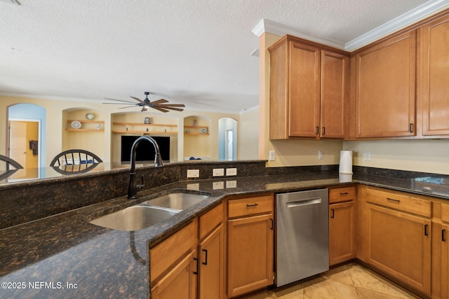 kitchen featuring a sink, a textured ceiling, ornamental molding, and dark stone countertops