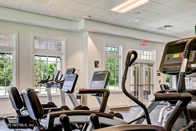 workout area featuring a drop ceiling, french doors, baseboards, and visible vents