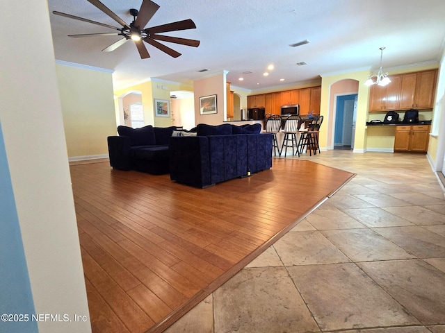 571 E Kings College Dr, Saint Johns, FL 32259 - living area featuring a ceiling fan, baseboards, ornamental molding, visible vents, and arched walkways