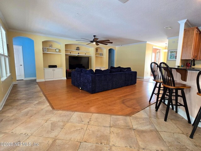 571 E Kings College Dr, Saint Johns, FL 32259 - living area with a healthy amount of sunlight, built in features, baseboards, and arched walkways
