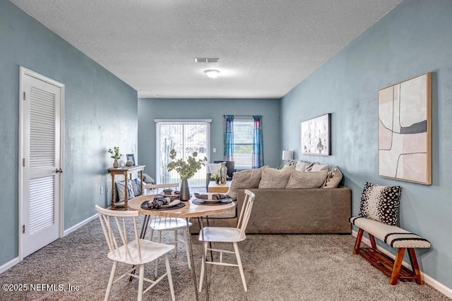 dining space featuring a textured ceiling, carpet, visible vents, and baseboards