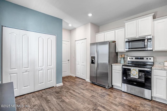 kitchen with dark wood-type flooring, white cabinetry, recessed lighting, stainless steel appliances, and baseboards