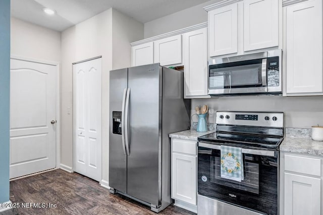 kitchen with light stone countertops, appliances with stainless steel finishes, dark wood-style flooring, and white cabinetry