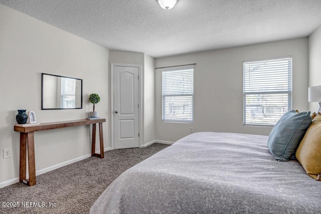 carpeted bedroom with baseboards and a textured ceiling