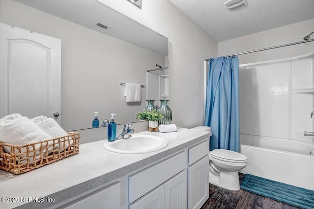 full bathroom featuring toilet, wood finished floors, visible vents, and a textured ceiling