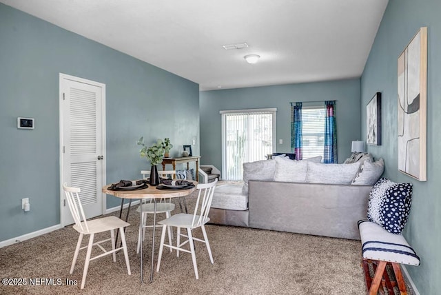 carpeted dining room featuring baseboards