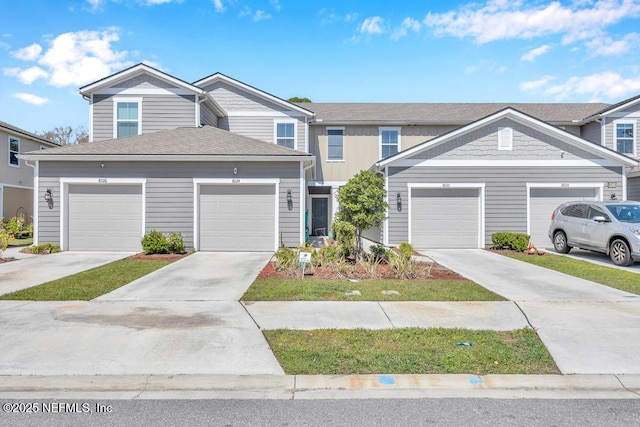 townhome / multi-family property featuring concrete driveway, a garage, and a shingled roof