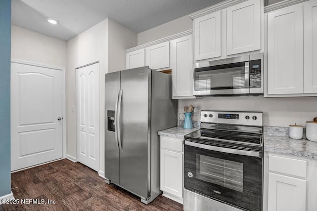 kitchen featuring white cabinetry, appliances with stainless steel finishes, dark wood-style flooring, and light countertops