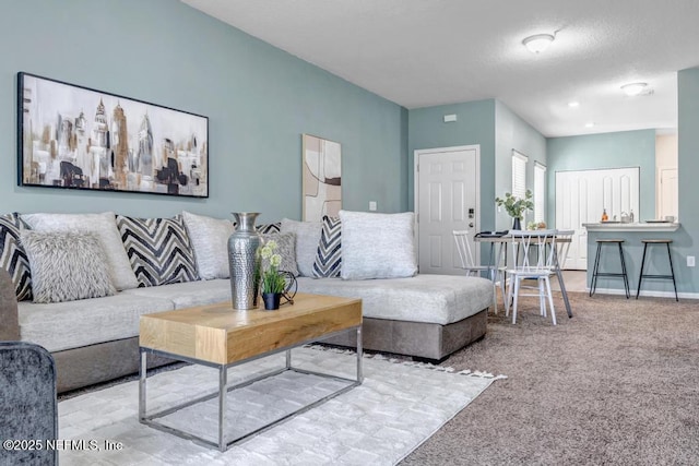 living room featuring baseboards, carpet floors, and a textured ceiling