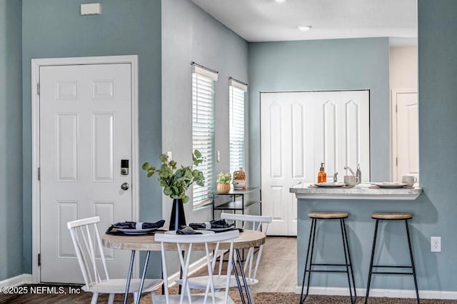 dining area with baseboards and wood finished floors