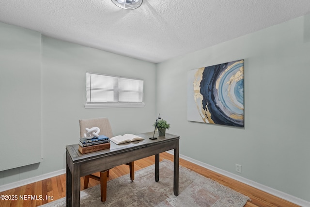 office with a textured ceiling, baseboards, and wood finished floors