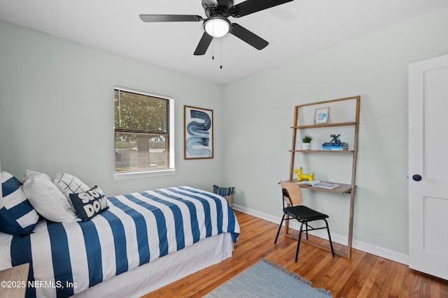 bedroom featuring ceiling fan, baseboards, and wood finished floors