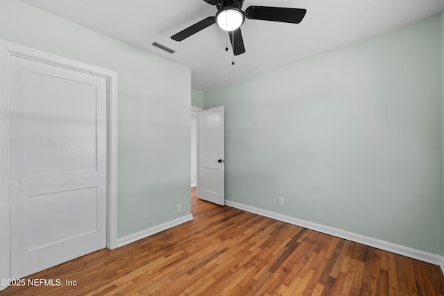 unfurnished bedroom with visible vents, light wood-style flooring, a ceiling fan, and baseboards