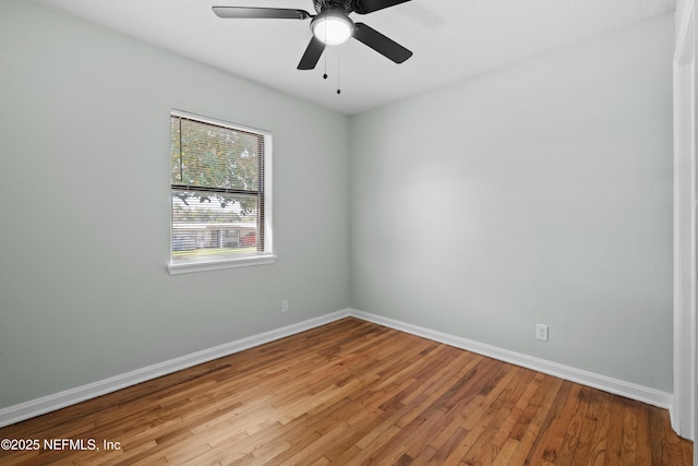 unfurnished room with baseboards, light wood-style flooring, and a ceiling fan